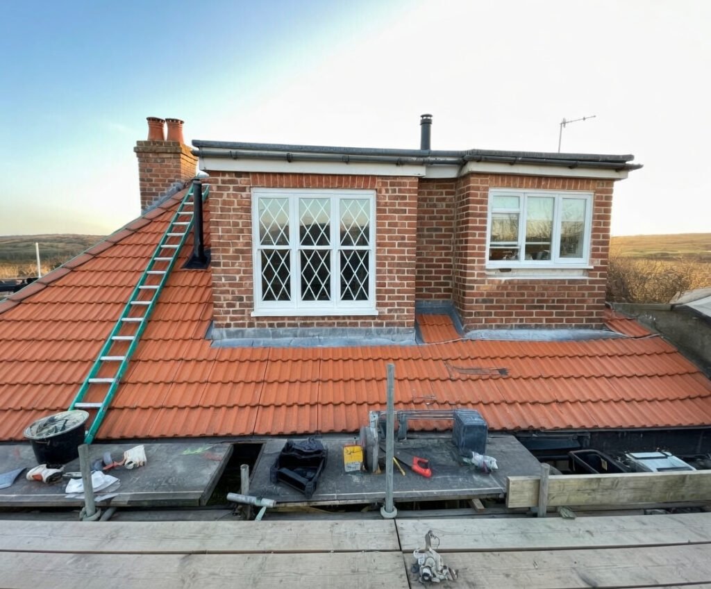 Local roofers from J.J Roofing providing emergency roof repairs in Hayes, West London, securing a leaking roof with heavy-duty tarpaulin after storm damage